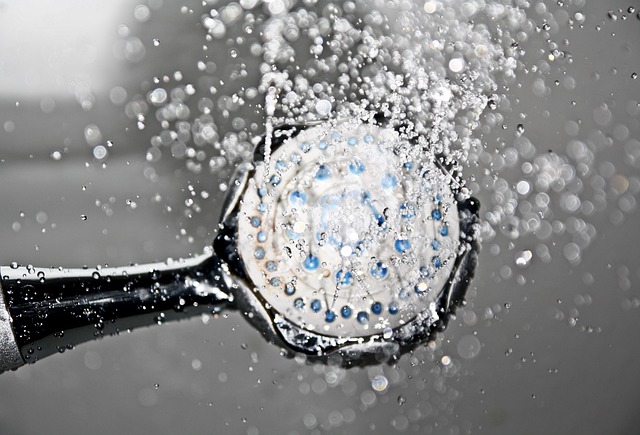 view from the side of a black and white shower head with water coming out